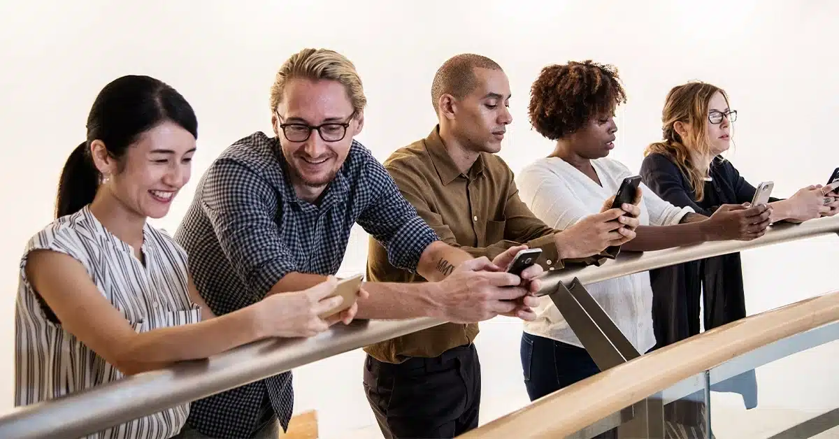 A diverse group of people using smartphones, symbolizing access to global talent